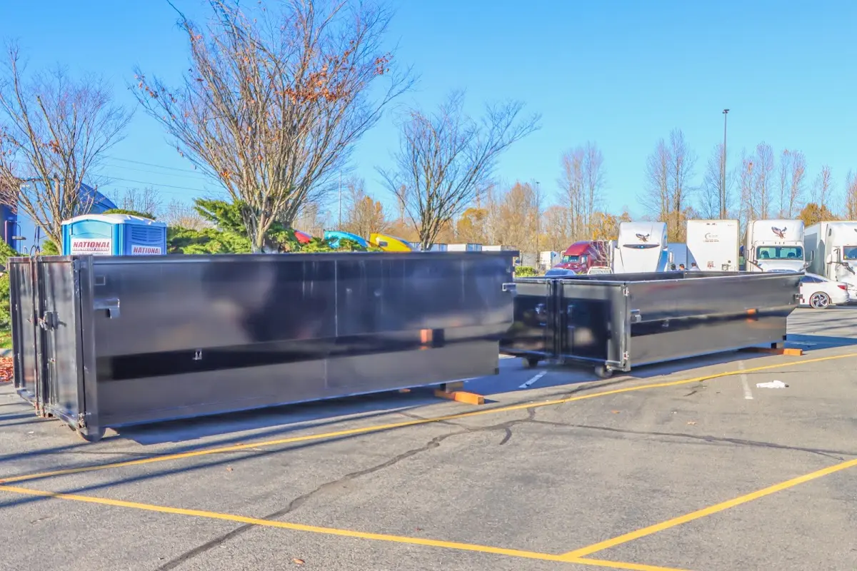 Professional dumpster rental service with roll-off container on residential driveway in Monitor